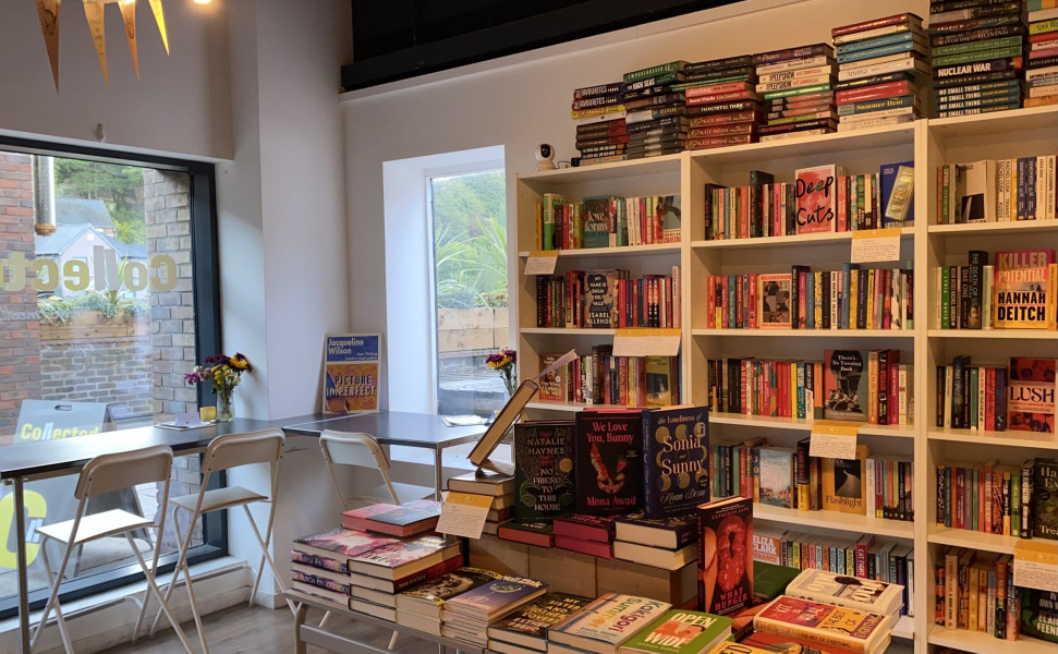 Inside of shop with bays of bookshelves next to the window