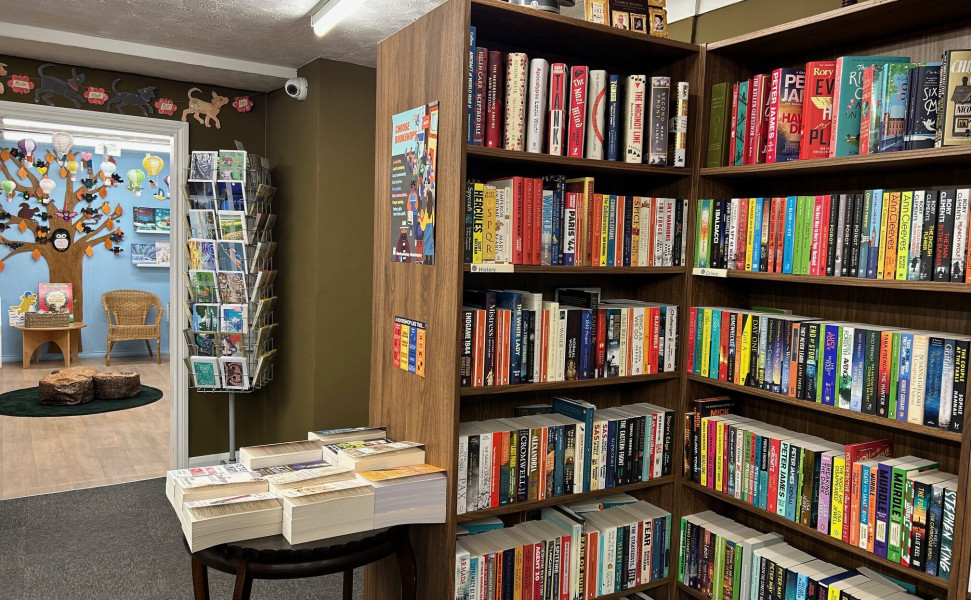 Bookshelves lined with books and also a table with books displayed