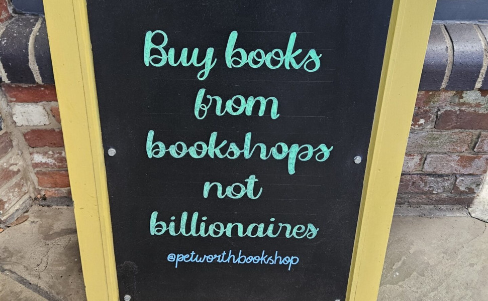 Display board with buy books from bookshops quote
